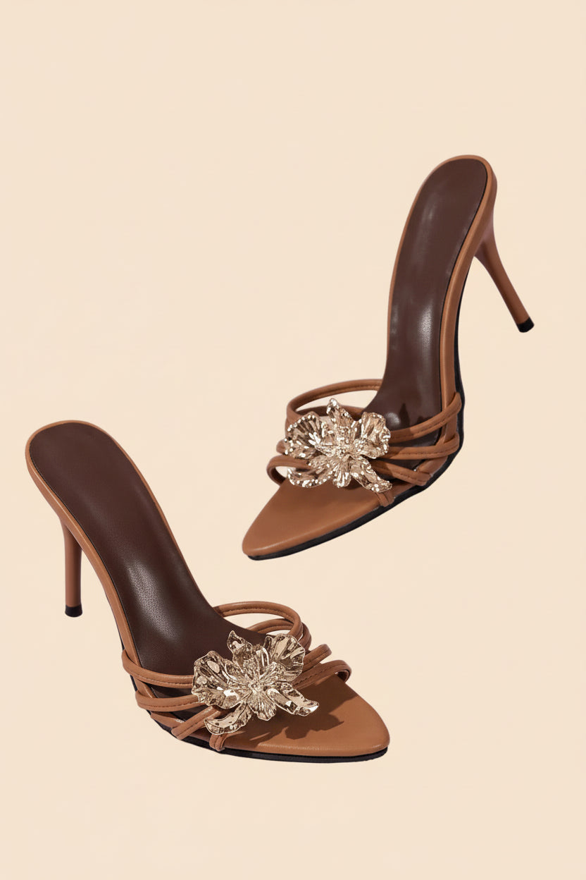 Braune High-Heel-Sandalen mit schmalem Absatz und goldener Blumenverzierung vorne. ✨