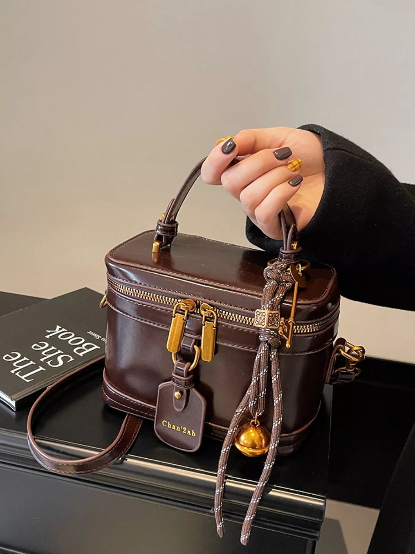 Stella - Koffertasche Mini in Braun, elegante Damentasche mit markanter Form und liebevollen Details.