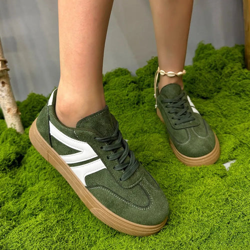 Grüne Sneaker mit weißen Streifen und brauner Gummisohle. 👟
