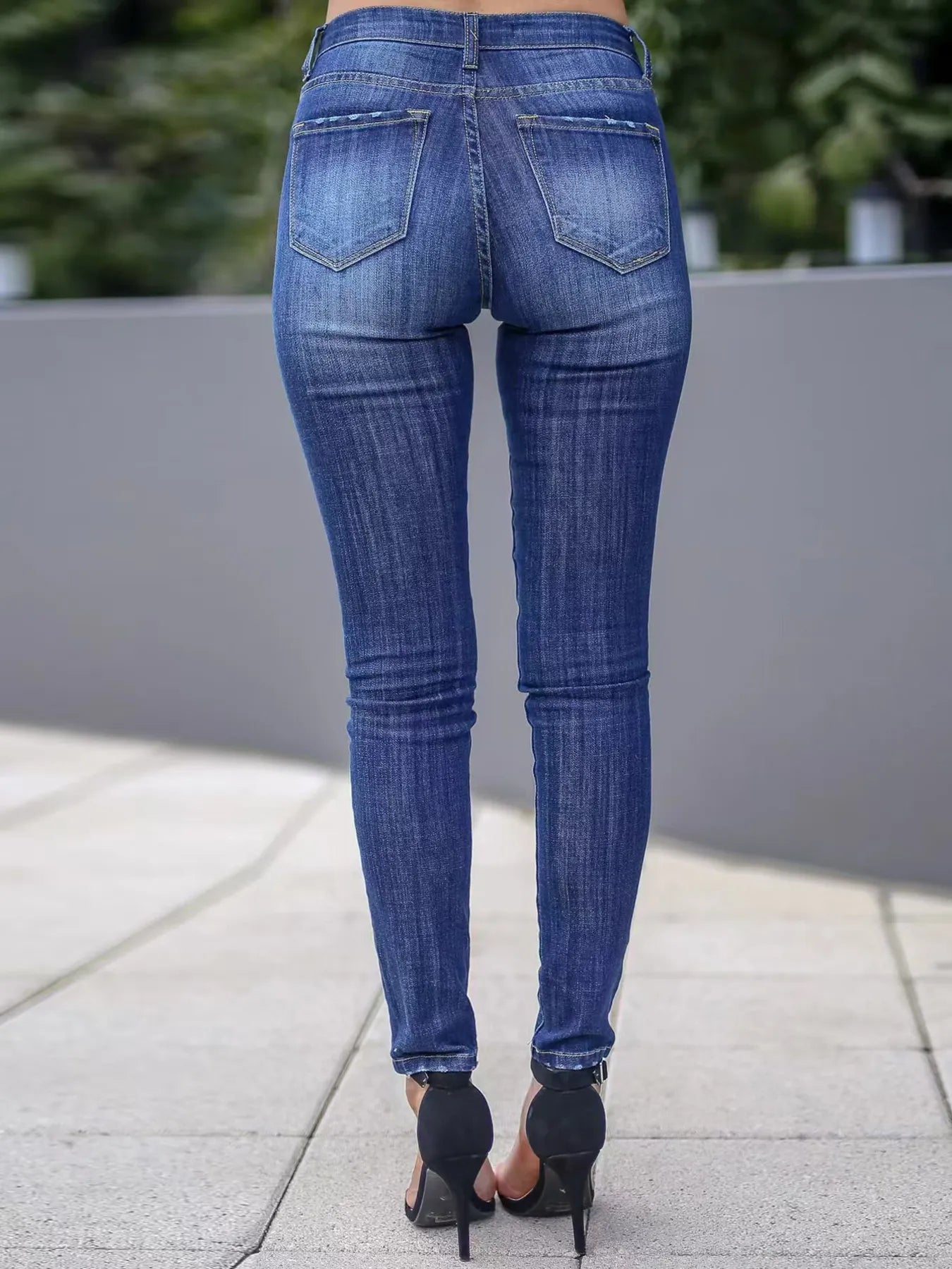 Rückansicht einer engen blauen Skinny-Jeans mit zwei Gesäßtaschen und leichter Waschung