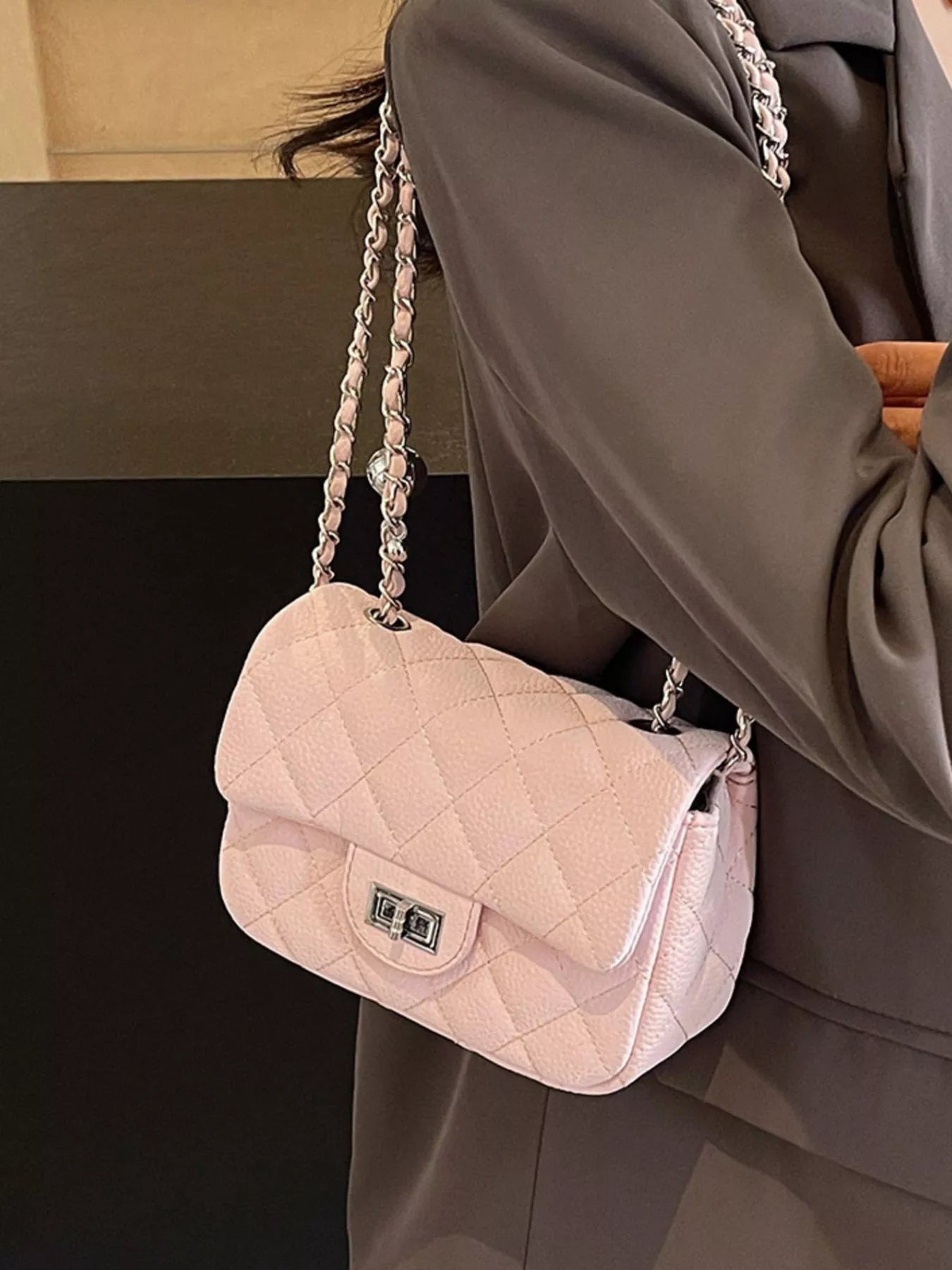 Lyra - Crossbody Tasche in zartem Rosa, elegantes Stepp-Design mit Ketten-Elementen, perfektes Accessoire.