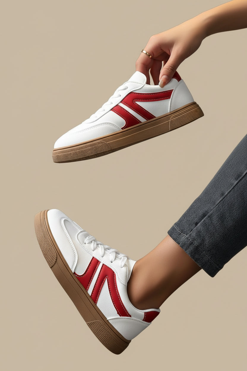 Weiße Sneaker mit roten Streifen und brauner Gummisohle. 👟