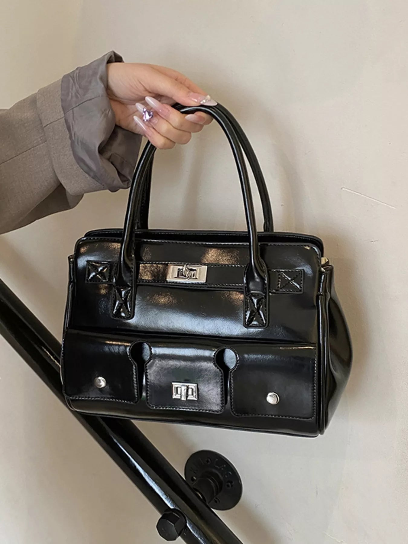 Schwarze Handtasche mit kurzen Tragegriffen, Fronttaschen und silbernen Verschlüssen. 👜🖤