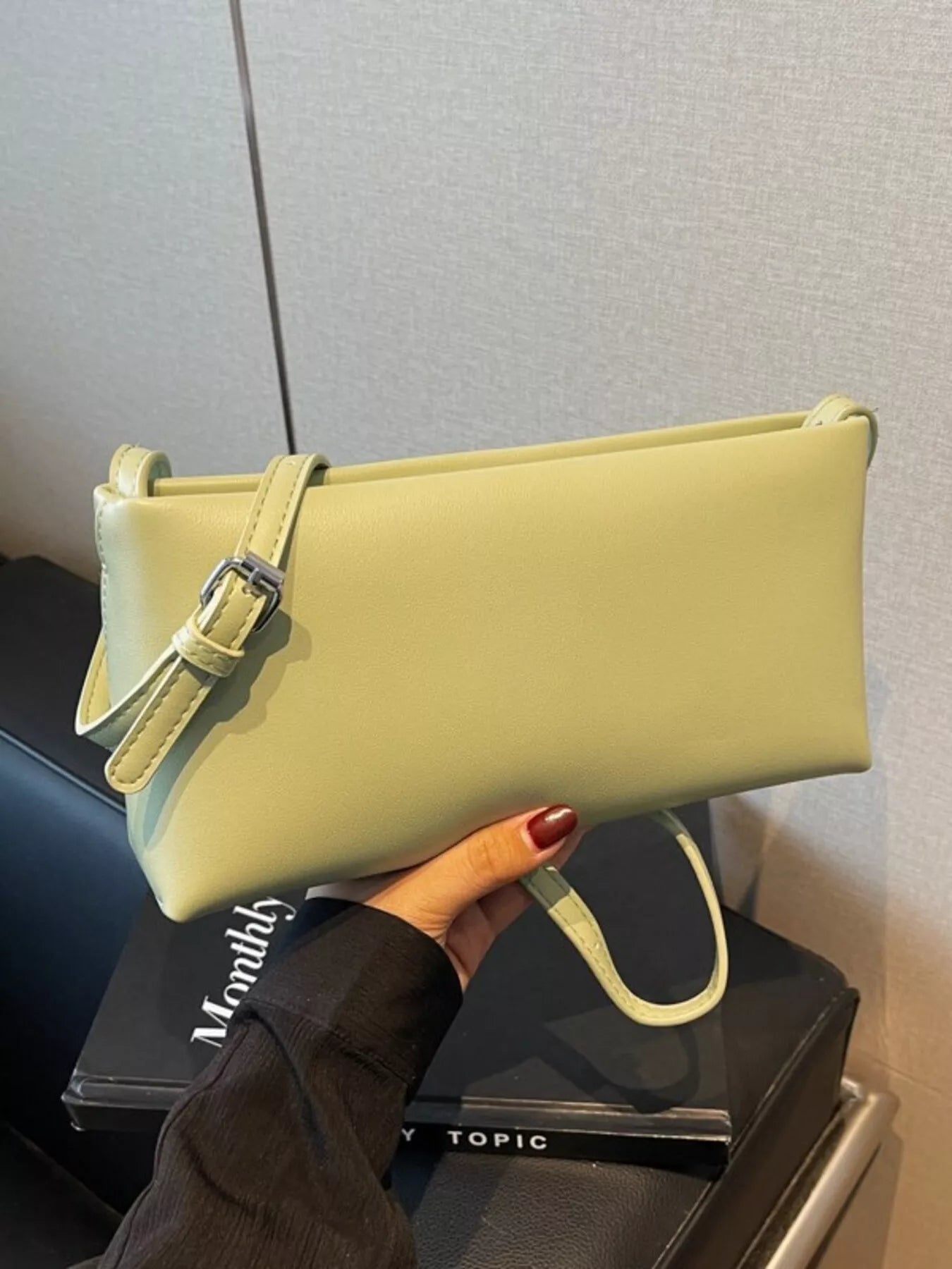 Schmale hellgrüne Schultertasche mit verstellbarem Riemen und Schnalle. 👜
