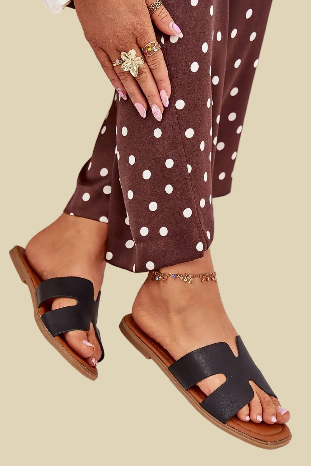 Elegante schwarze Damen Pantoletten kombiniert mit einer gemusterten Sommerhose.