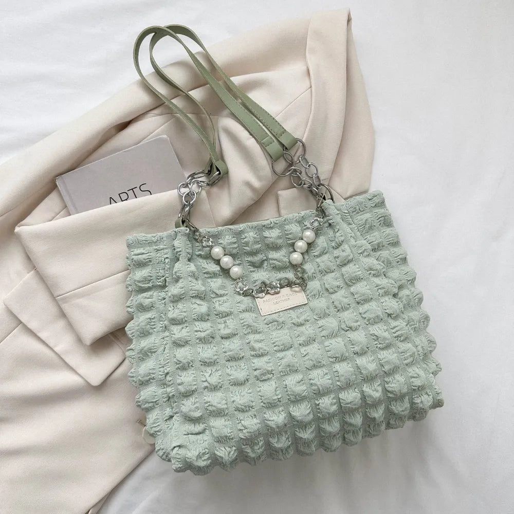 Hellgrüne Handtasche mit strukturierter Oberfläche, kurzen Trägern und dekorativer Kette mit Perlen