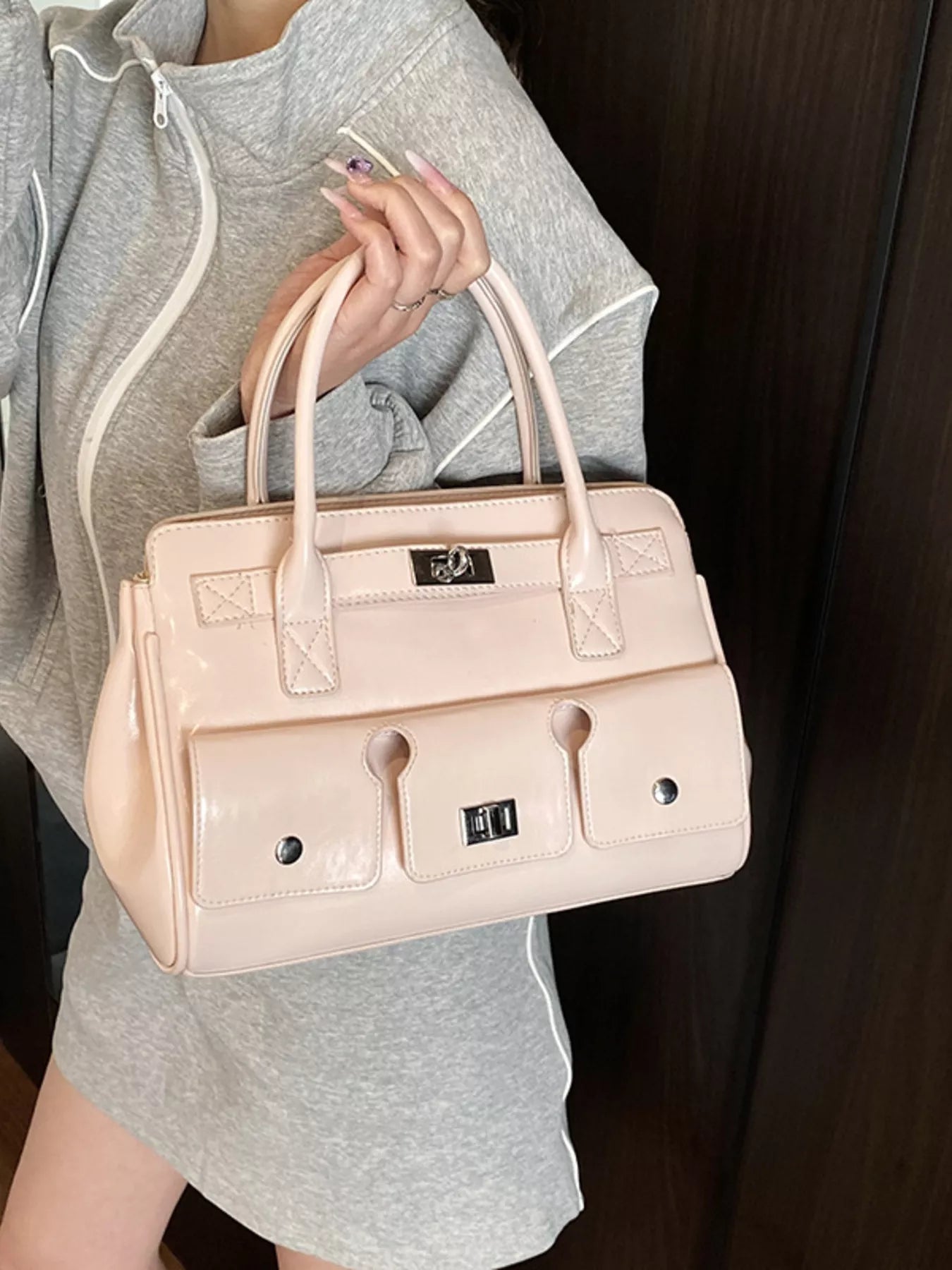Hellbeige Handtasche mit kurzen Tragegriffen, Fronttaschen und silbernen Verschlüssen. 👜✨