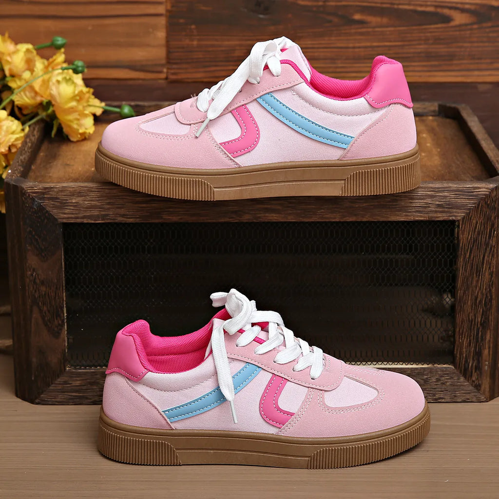 Rosa Sneaker mit weißen Schnürsenkeln, hellblauen Streifen und brauner Gummisohle. 👟